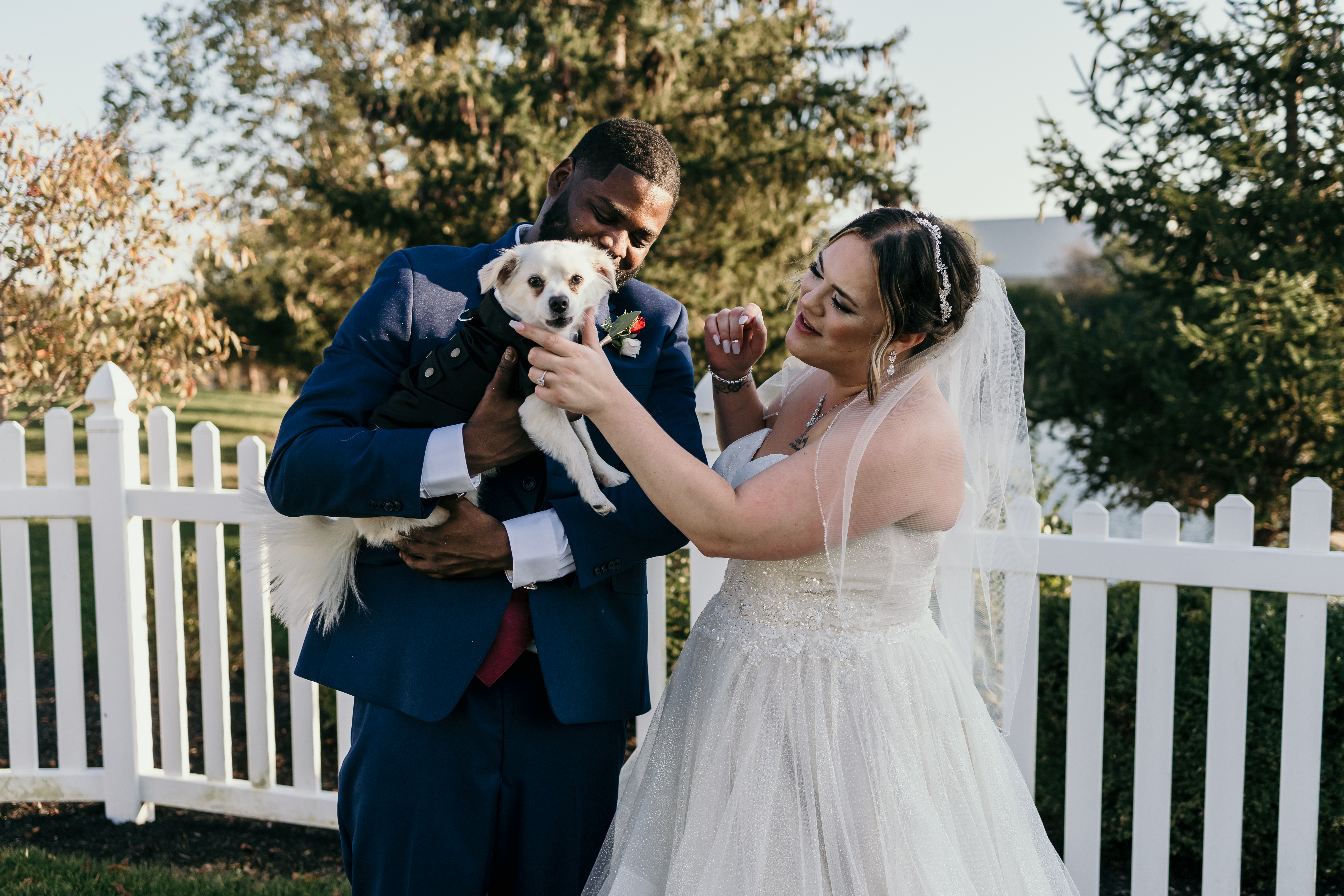 a couple with their dog on their wedding day
