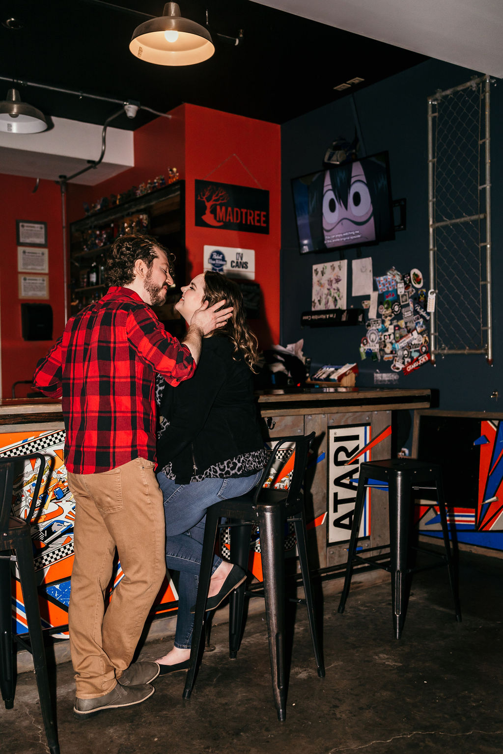 engaged couple during engagement session at arcade bar in northside outside of downtown cincinnati, ohio